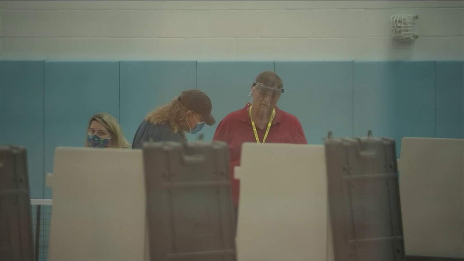 Poll workers help voters prevent the spread of virus